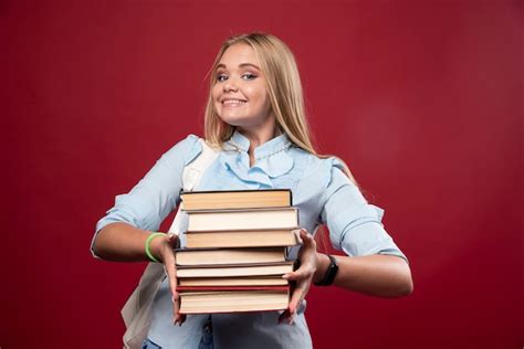 Mulher Loira Estudante Segurando Uma Pilha De Livros E Parece Positiva