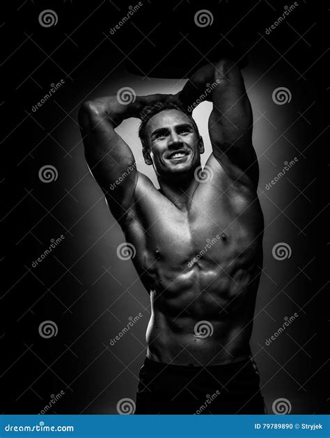 Hombre Joven Del Atleta Muscular Que Presenta En Estudio Blanco Y Negro