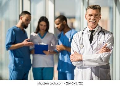 Smiling Mature Male Doctor Standing Hospital Stock Photo 1208448838