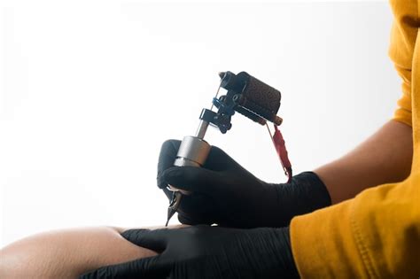 Premium Photo Master Makes A Tattoo On The Man Leg