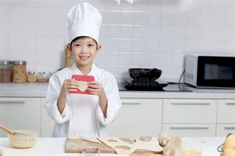 Portrait Of Happy Smiling Asian Boy In White Chef Uniform With Hat