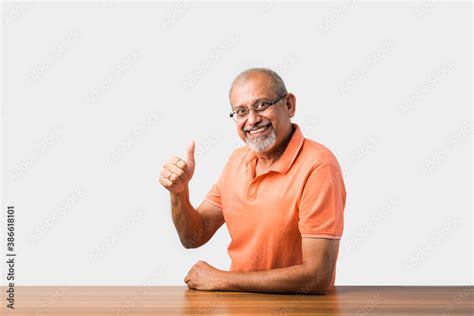 Portrait of senior or old Indian man at table Stock Photo | Adobe Stock