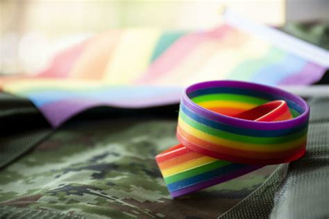 Rainbow Flag And Rainbow Wristbands On Camouflage Background Concept For Celebrations Of Lgbt