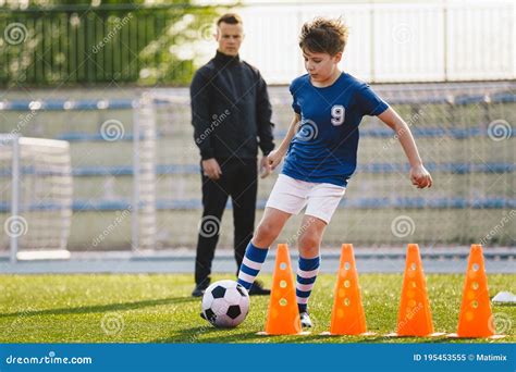 Kid Soccer Player Dribbling Through Cones Boy In Soccer Uniform