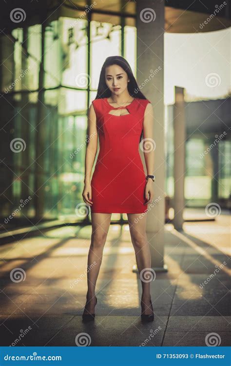 Modelo Asiático Bonito Da Menina No Vestido Vermelho Que Levanta No