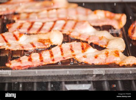 Las Tiras De Tocino Cocinado En Plancha De Hierro Fundido En Piscina