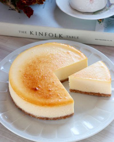 A Cheesecake On A Plate Next To A Book