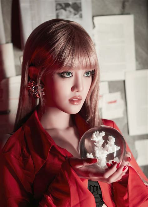 A Woman In Red Holding A Snowball With White Flakes On Its Face