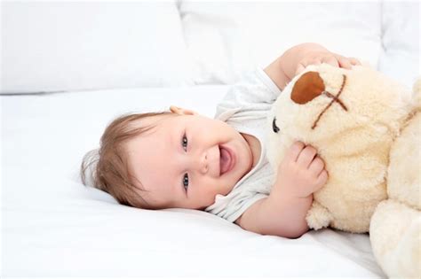 Lindo Beb Jugando Con Oso De Peluche En La Cama Foto Premium