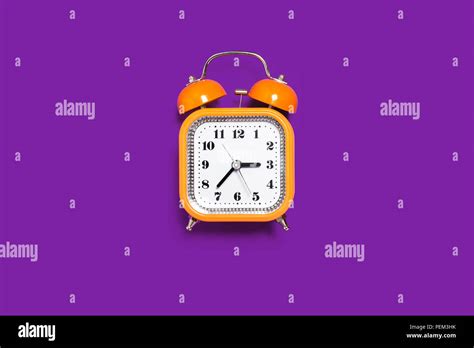 Orange Alarm Clock On The Purple Background Stock Photo Alamy