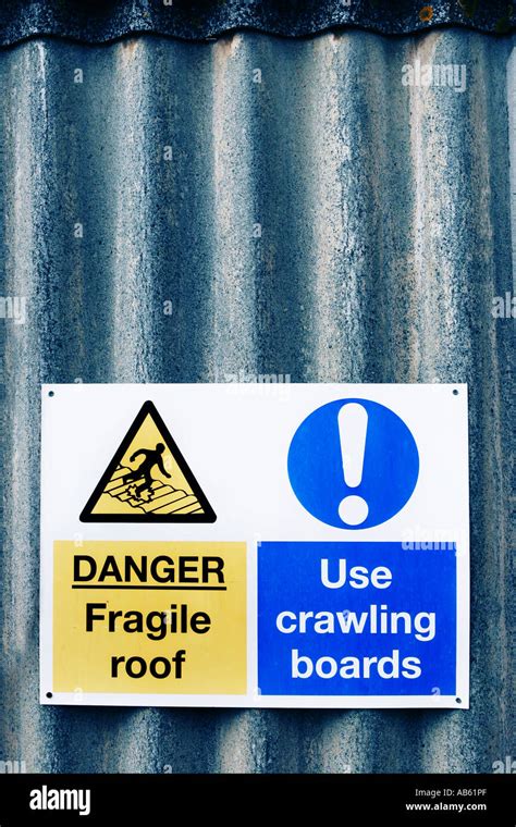 Warning Sign Showing Danger Of Fragile Roof And To Use Crawling Boards