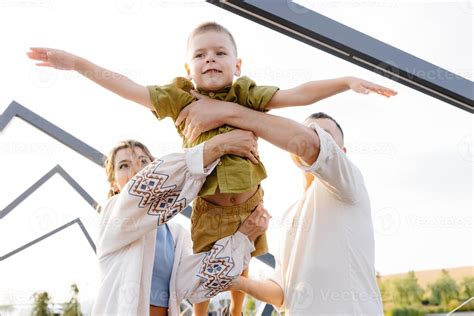 On a Beautiful Sunny Day, Parents Enjoy Lifting Their Child up in the