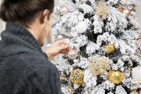 Vista traseira do homem que decora a árvore de natal Foto Grátis