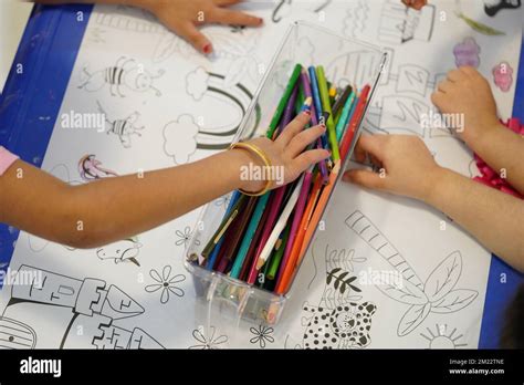 Un enfant s assoit et colore un motif de papier de couleur géant L