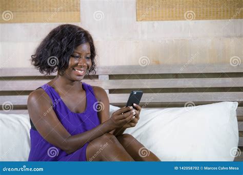 Happy Black African American Woman Sitting On Bed Using Internet Mobile