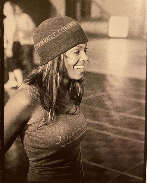 A Black And White Photo Of A Woman Wearing A Beanie Smiling At The Camera