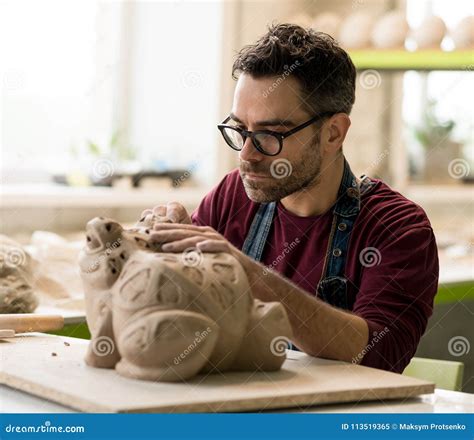 Ceramist Dressed In An Apron Sculpting Statue From Raw Clay In Bright