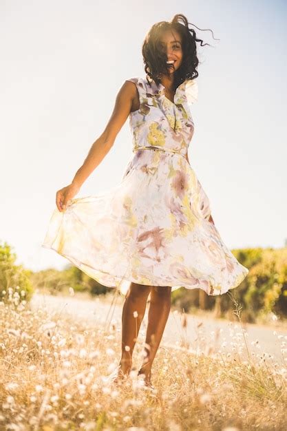 Premium Photo Happy Pretty Woman Standing On The Grass In Floral Dress