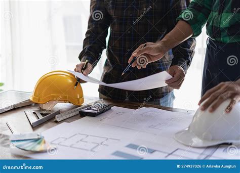 Engineer Pointing At Blueprint And Using Laptop To Draw Project Design