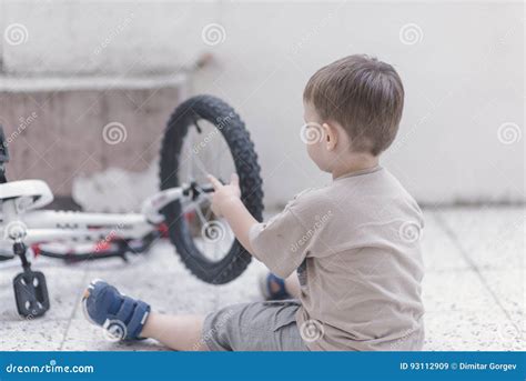 Litet Barn Som Fixar En Cykel Fotografering F R Bildbyr Er Bild Av