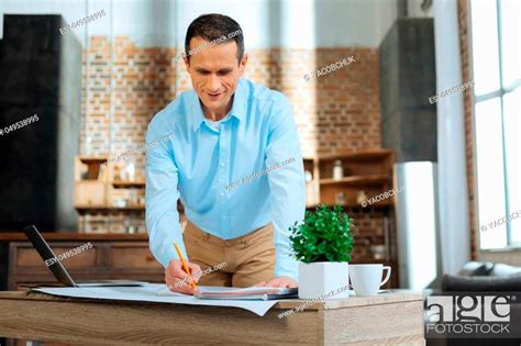 Making Sketch Positive Delighted Brunette Bowing Head While Looking At