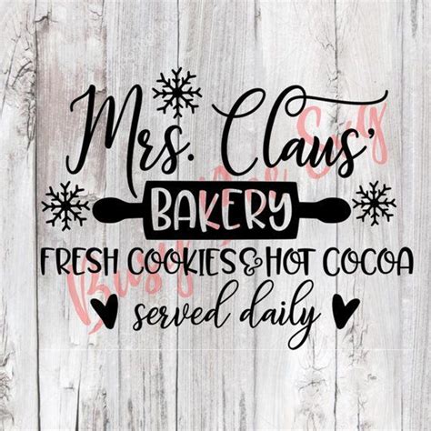 A Sign That Says Mrs Claus S Bakery Fresh Cookies Hot Cocoa Served Daily