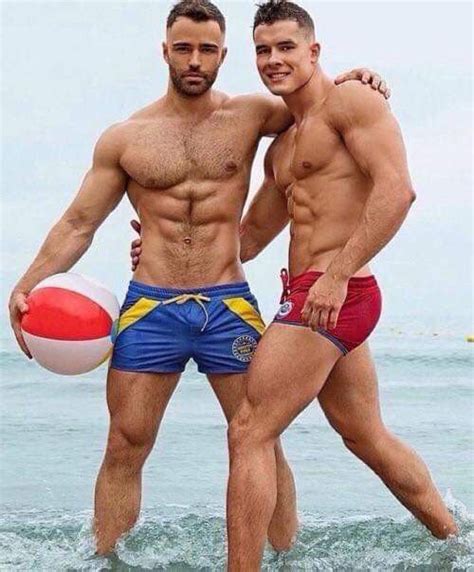 Two Men Standing In The Ocean With One Holding A Beach Ball While The