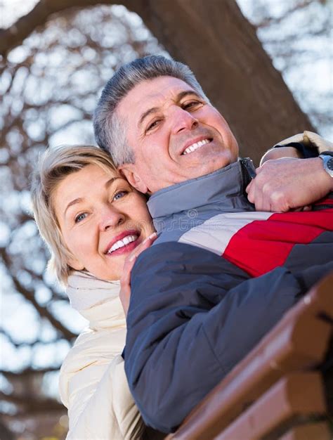 Positive Mature Married Couple Holding Hands Each Other In Park Stock