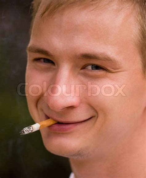 A Young Man Smoking Cigarette Focus Is Set At His Face Stock Photo