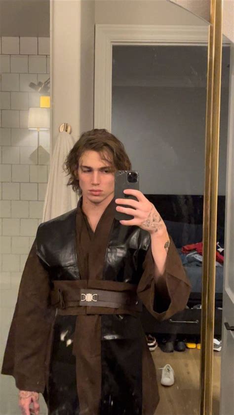 A Man Is Taking A Selfie In The Mirror Wearing A Robe And Holding A