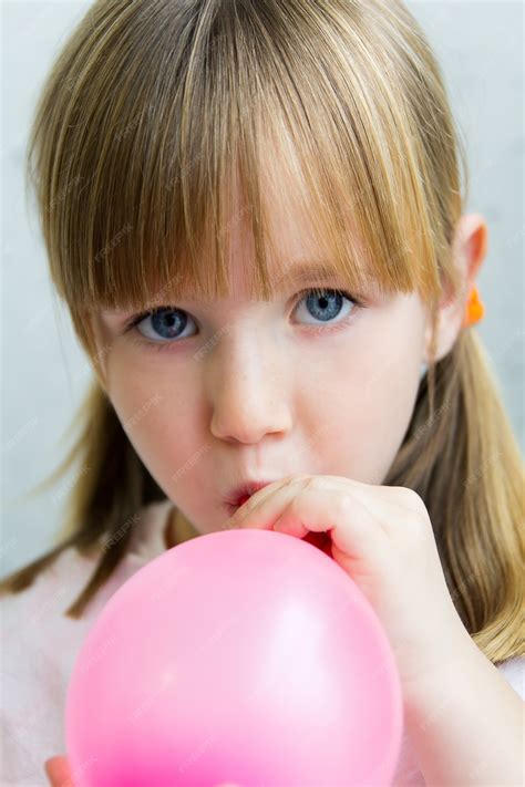 Mignon Petite Fille Gonflant Un Ballon Rose Dans La Cuisine Photo