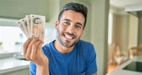 Joven Guapo Sonriendo Feliz Sosteniendo Billetes De Libras Inglaterra