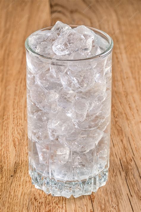 Premium Photo Glass Of Cold Water With Ice On Wooden Table