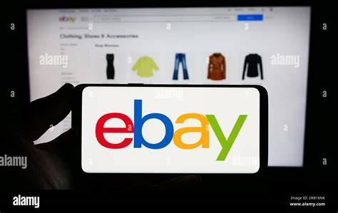 Person Holding Smartphone With Logo Of US E Commerce Company EBay Inc