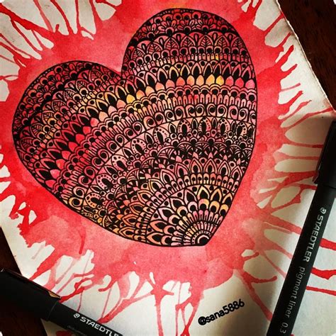 a heart drawn on top of a piece of paper next to a marker and pen