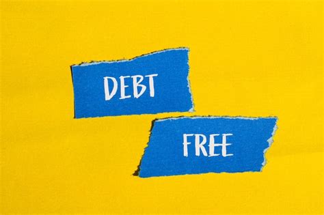 Premium Photo Debt Free Words Written On Ripped Blue Paper Pieces With Yellow Background