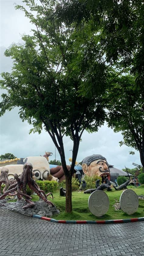 A Group Of Sculptures Sitting On Top Of A Lush Green Field