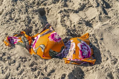 A Colored Bikini Top Lays In The Sand At A Local Beach Stock Photo