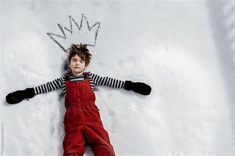 Boy Lies On His Back In The Snow By Stocksy Contributor Cara Dolan