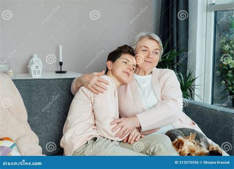 Smiling Neutral Gender Woman And Senior Mother Hugging Elderly Mother