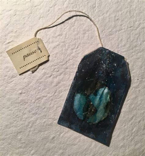 a piece of blue glass sitting on top of a white surface next to a tag