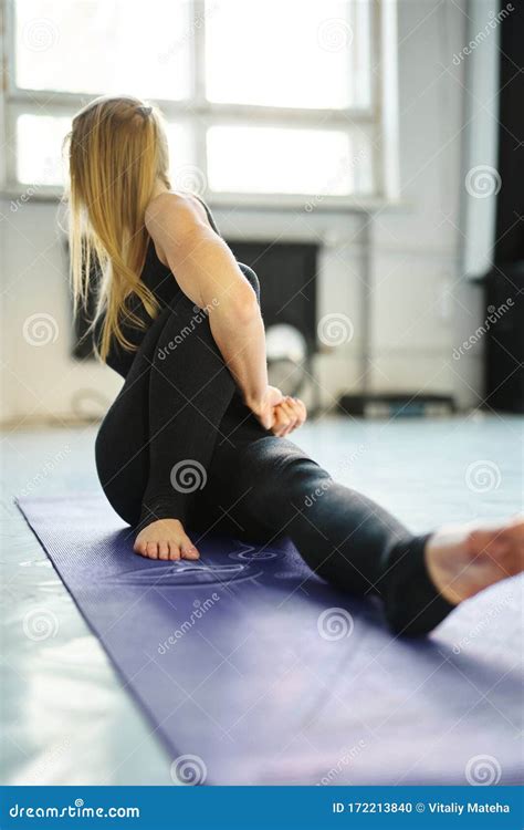 Sporty Flexible Blonde Woman In Black Sportswear Practicing Yoga In