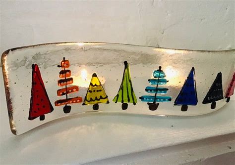 A Decorative Glass Plate With Christmas Trees On The Front And Sides