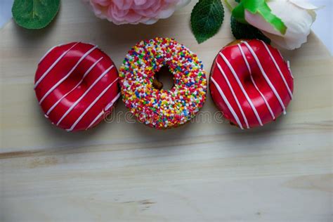 Drie Donuts Van Verschillende Kleuren Liggen Op Een Houten Standaard