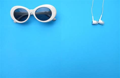 Premium Photo White Headphones And Sunglasses On Blue Background