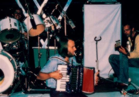 A Man Playing An Accordion While Sitting In Front Of Drums And Other