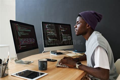 Young Serious African American Male Programmer Working Over New