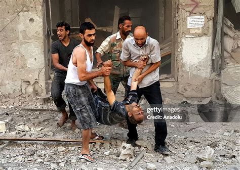 Syrian people evacuate the air attack victims from the scene of a ...