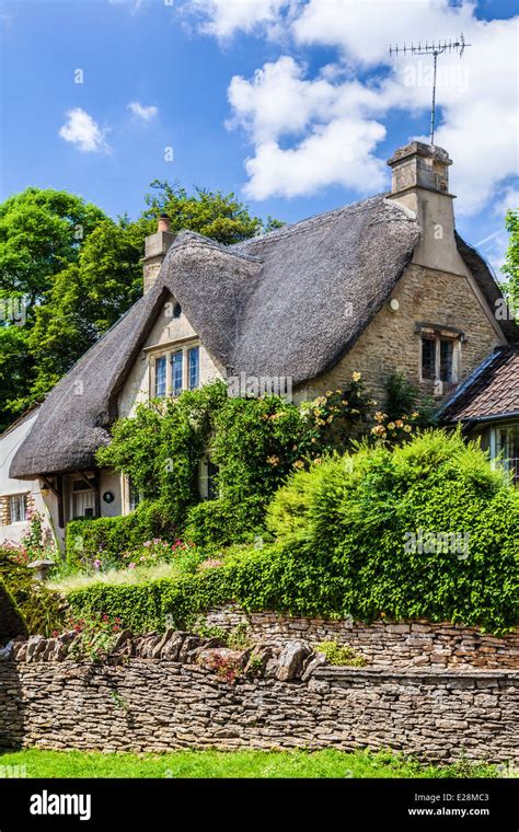 The Picturesque Thatched Cottage In The Cotswold Village Of Castle