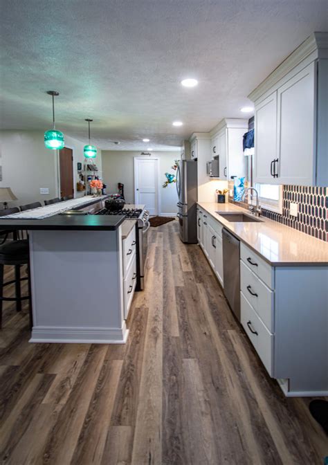 White Kitchen With Blue Tiled Backsplash And Two Tier Island